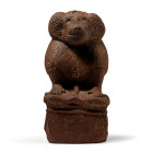 New Kingdom, circa 1550-1070 B.C. Carved in a typical pose, sitting on its haunches with its tail curving around the right side, its front paws restin...
