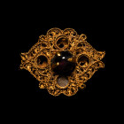 2nd-1st century B.C. Rosette panel with central claw setting and four voided cells, scrolled filigree and beaded wire; garnet cabochon to centre. 3.32...