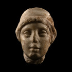 3rd-2nd century B.C. Carved in the round with carinated diadem in the hair, heavily lidded eyes, small mouth with pursed lips. Cf. Beutler, F. et al.,...