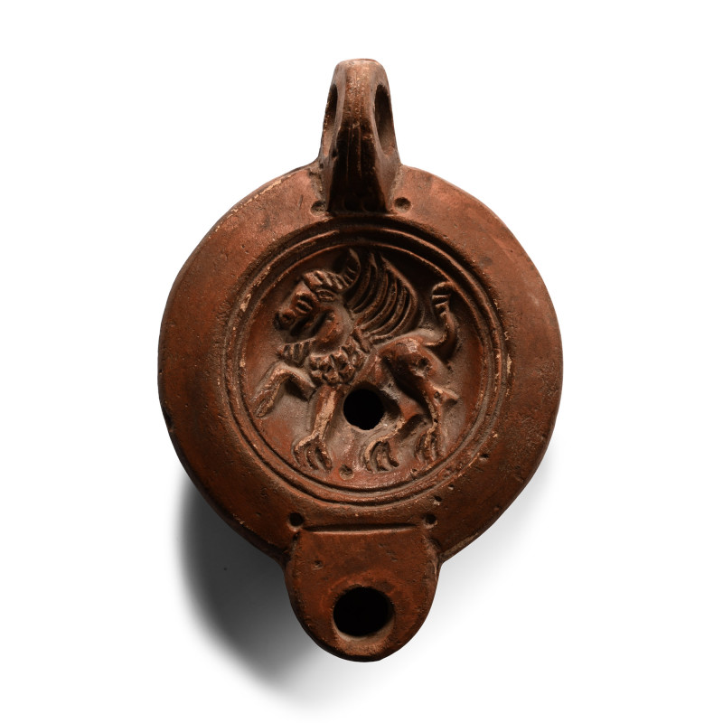 Roman Terracotta Lamp with Griffin. 1st-2nd century A.D. Discoid body and sunken...