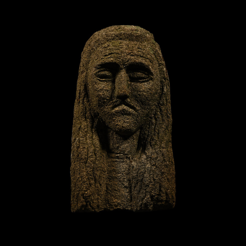 Celtic Style Stone Head. 20th century A.D. Carved in the round bust with long ha...