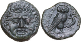 Sicily. Kamarina. AE Tetras, c. 420-405 BC. Obv. Facing gorgoneion with protruding tongue. Rev. KAMA. Owl standing right, head facing, grasping lizard...
