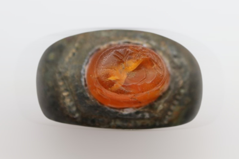 Roman bronze ring with a solid band and dark brown patina. Orange/red carnelian ...