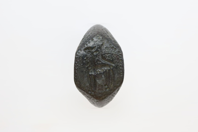 A bronze ring with a solid band and dotted bezel engraved with a mythical beast ...