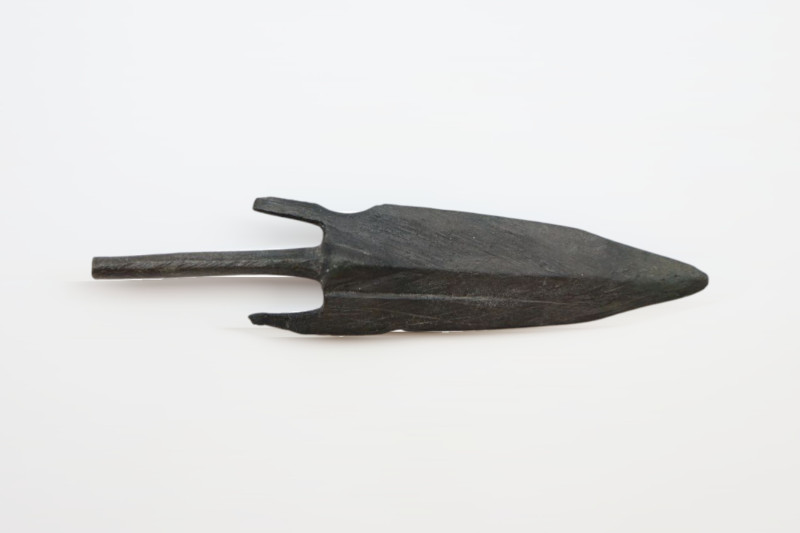 A heavy bronze arrowhead with a tail and two barbs; 10.87 grams, 66mm in length....