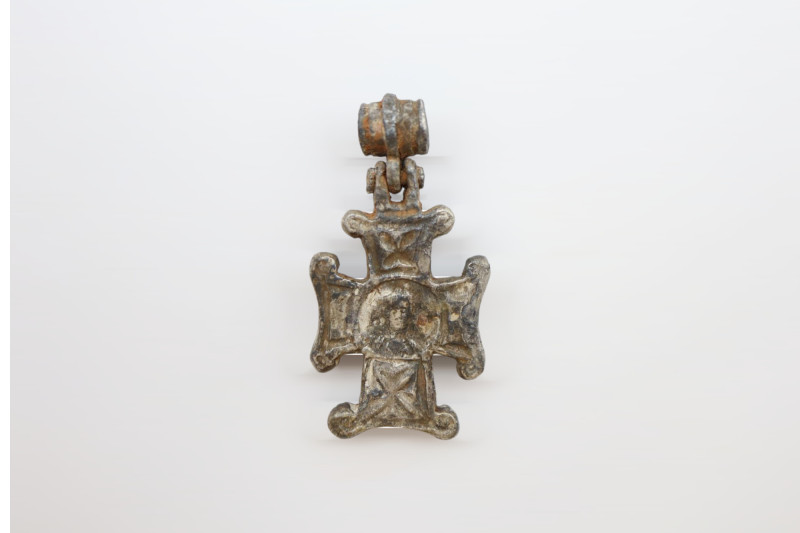 A silver decorated cross pendant with loop intact. Saint on the obverse, inscrip...
