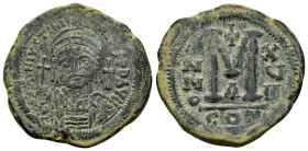 JUSTINIAN I, (527-565 AD). Ae. Follis. Constantinople.

Obv : D N IVSTINIANVS P P AVC.
Helmeted, cuirassed bust facing, holding cross on globe and shi...