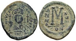 JUSTINIAN I, (527-565 AD). Ae. Follis. Constantinople.

Obv : D N IVSTINIANVS P P AVC.
Helmeted, cuirassed bust facing, holding cross on globe and shi...