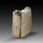 Limestone, W 20cm, H 20cm, D 7.5cm. Tapering headrest with a fascia at the base and a concave, sidewards projecting top. Flat high reliefs on the narr...
