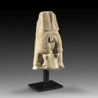 Egyptian limestone fragmentary statue of the snake-headed goddess Meret Seger, wearing a full wig with braided fringe and double-feathered headdress. ...