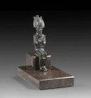 Mummy-like figure of the god Osiris, seated, wearing an atef crown and uraeus. A ceremonial beard is attached under the chin. The god holds a crosier ...