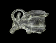 Cosmetic spoon in the form of a recumbent ibex, made of darkgrey and green schist, L 4.5cm, W 3cm. The bowl of the spoon survives and is carved in the...