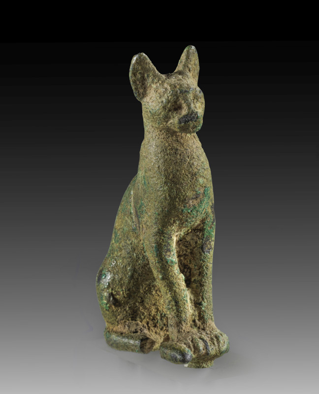 A bronze figure of a cat seated with erect ears representing the goddess Bastet,...
