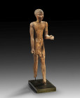 Statuette of a striding man: H 45.1cm, W 11.5cm, D 13cm. Wood with remnants of blue and red painting. The left, angled arm was worked separately from ...