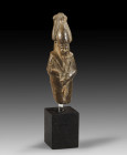Upper part of a stone statuette of Osiris with hieroglyps at the back pillar, H 7.5cm. Late Period, 6th - 4th century BC. Broken above the knees, miss...