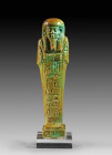 Ushabti of Padjhor-Mehen, faience, light blue glaze. Mummiform, with arms crossed on chest, wearing tripartite wig and a vertical hieroglyphic inscrip...