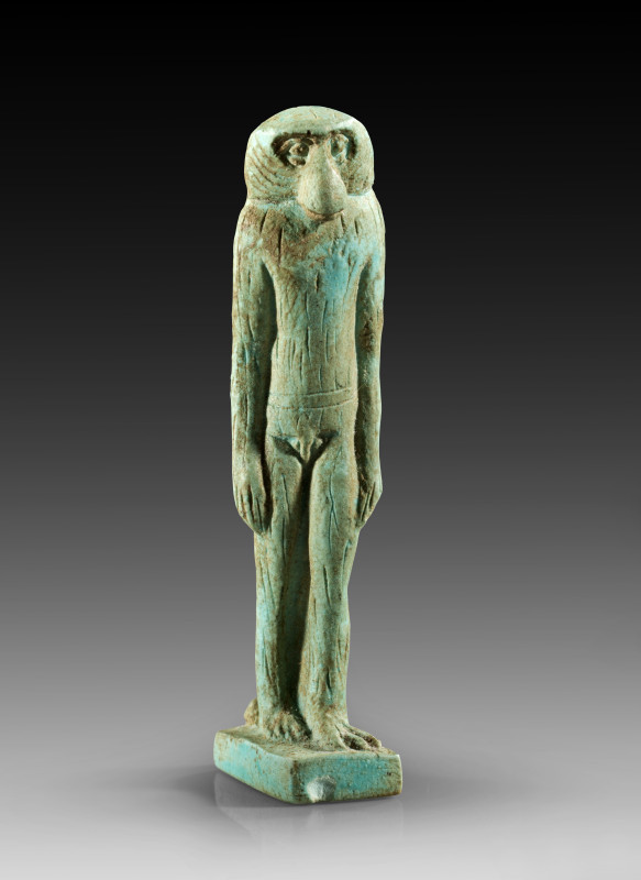 Light turquoise faience amulet of the god Thot in the guise of a striding baboon...