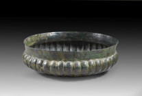 Neo-Assyrian ribbed bronze bowl. 9th - 7th century BC. H 4.9cm, ø 16.1cm. Flat donation bowl made of chased bronze sheet with plastic ribs and convex ...