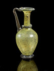Jug. Eastern Mediterranean, 4th - 5th century AD. H 20,5cm. Green translucent glass. Globular body with tall neck. Foot, ring trail around neck, handl...