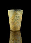Richly decorated cup. Roman, 2nd - 4th c. AD. H 8,3cm. Colourless clear glass. Conical body with elaborate incised patterns. The unusual precision and...