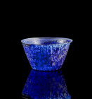 Spotted glass bowl. ø 10,2cm; H 5,8cm. Roman, 1st century AD. Blue glass with opaque white spots. Mould-blown, with tongue pattern on the outside. Res...