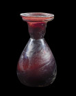 Flasche. Römisch, 3. - 4. Jh. n. Chr. H 11cm. Auberginefarbenes Glas. Birnenförmiger Corpus auf flachem Boden mit Heftnarbe. Starke Einschnürung am Ha...