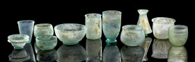 Sammlung gläserne Schalen und Becher. Römisch, 2. - 4. Jh. n. Chr. Alle aus grünem, irisiertem Klarglas. a) Schale mit Standfuß. H 6,5cm. ø 12,6cm. In...