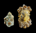 Glasanhänger in Form von Köpfen. Phönizisch, 5. - 4. Jh. v.Chr. Aus verschieden farbigem Glas in Sandkerntechnik hergestellt. a) L 3,5cm. Bärtiger Kop...