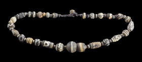 Halskette mit schwarzen Glasperlen. Phönizisch, ca. 600 - 100 v. Chr. L 50cm. Bestehend aus 55 schwarzen, gemusterten Glasperlen verschiedener Größen....