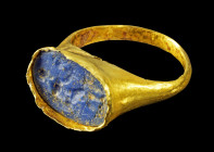 Kindergoldring mit Lapislazuli. Römisch, 1. - 2. Jh. n. Chr. 0,83g, Ringgröße 40. Schmale Schiene mit hoher Fassung, in der eine längsovale Gemme aus ...