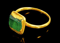 Goldring mit Smaragd. Frühbyzantinisch, 6. Jh. n. Chr. 2,38g, Ringgröße 51. Dünne, runde Ringschiene mit quadratischer, kissenartiger Fassung mit Smar...