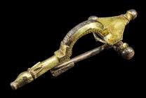 Vergoldete Silberfibel. Römisch-germanisch, 2. - 3. Jh. n. Chr. L 7,8cm. Bügelfibel, deren Fuß in einem Hundekopf endet. Die dreieckige Kopfplatte wei...
