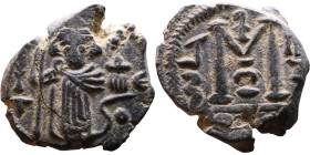 al-Malik ibn Marwan (687-705), Byzantine style folis Obverse: Imperial figure holding globe and cross Reverse: M and inscription

18mm 3,88g