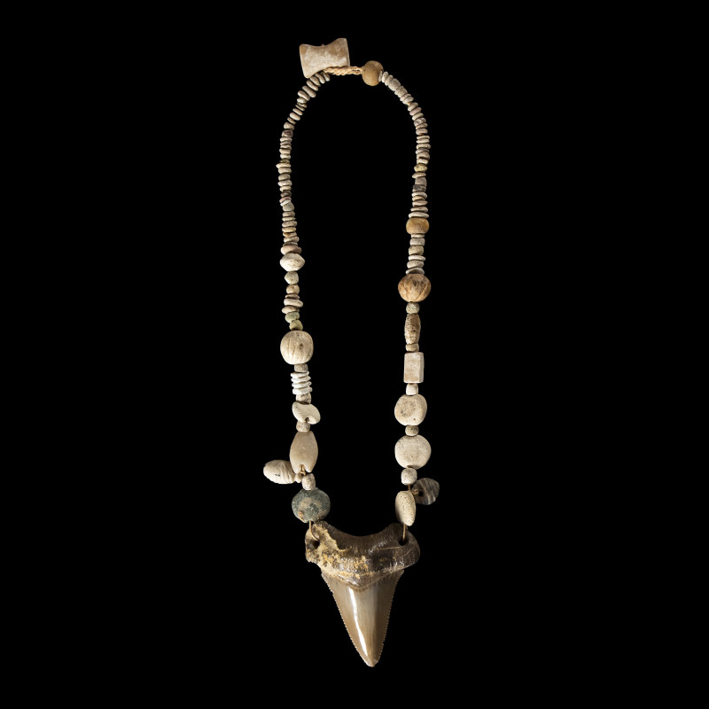 An Egyptian Predynastic restrung necklace with beads and a central shark tooth....