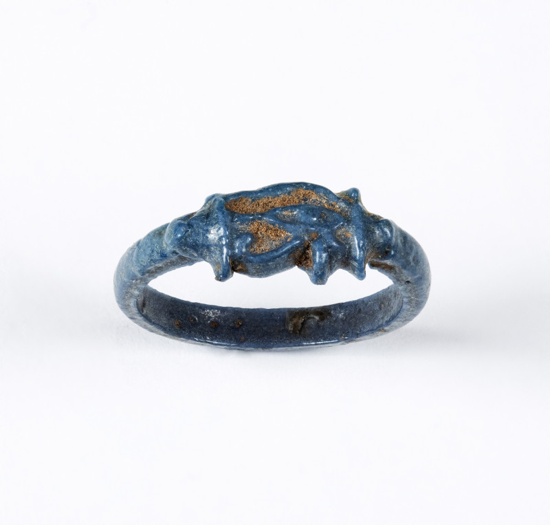 AN EGYPTIAN BLUE GLAZED FAIENCE UDJAT RING.
New-Kingdom, Dynasty 18, ca. 1400-1...