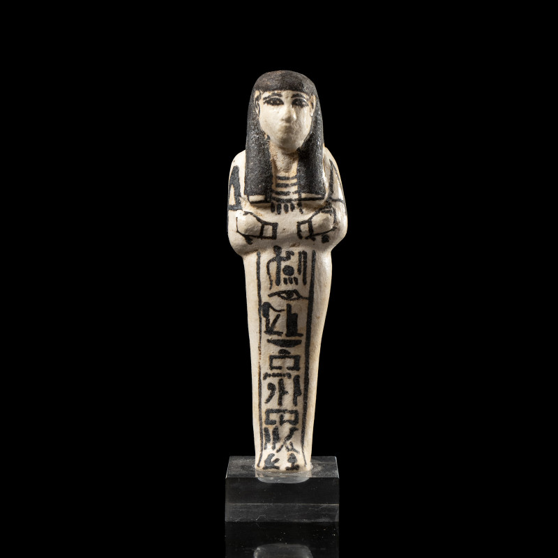 AN EGYPTIAN WHITE FAIENCE GLAZED SHABTI FOR THE LADY OF THE HOUSE INHAY.
New-Ki...