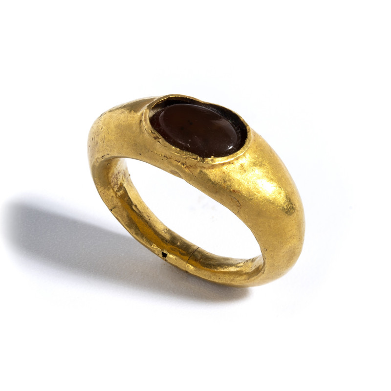 *A ROMAN GOLD RING SET WITH A GARNET.
1st century A.D.
Diam. 2,4 cm

Provena...