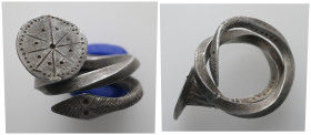 Spiral silver ring with decorated bezel and serpent-head terminal 
Coiled silver ring formed from a single thick wire, tapering toward the ends and sp...