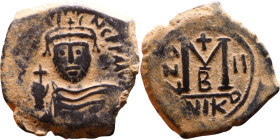 Heraclius (610-641) Follis. Obverse: Helmeted and cuirassed bust facing, holding globus cruciger and shield., Reverse: Large M above cross, ANNO

27...