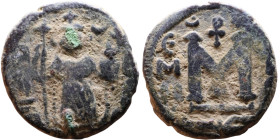 al-Malik ibn Marwan (687-705), Byzantine style folis Obverse: Imperial figure holding globe and cross Reverse: M and inscription

18mm 4.43g