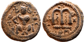 al-Malik ibn Marwan (687-705), Byzantine style folis Obverse: Imperial figure holding globe and cross Reverse: M and inscription

Artificial sand pa...