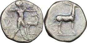 Greek Italy. Bruttium, Kaulonia. AR Stater, c. 475-425 BC. D/ Apollo advancing right, holding branch; small daimon running on Apollo's left arm; to ri...