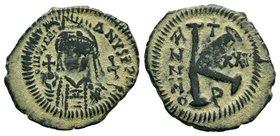 Justinian I, AE Half-Follis. Antioch. DN IVSTINIANVS PP AVG, helmeted, cuirassed bust facing, holding cross on globe and long sceptre, cross to right ...