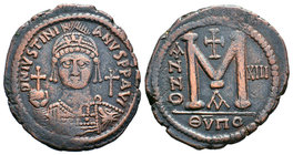 Justinian I, AE Follis. Antioch. DN IVSTINIANVS PP AVG, helmeted and cuirassed bust facing, holding cross on globe and shield with horseman motif, cro...