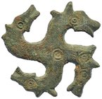 ROMA. Esvástica con los brazos rematados en cabezas de caballo. Siglo II-III d.C. Bronce. Diámetro 4,2 cm.