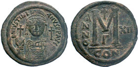 BYZANTINE.Justinian I, AE Follis. Constantinople. 527-565 AD. DN IVSTINIANVS PP AVG, helmeted, cuirassed bust facing holding cross on globe and shield...